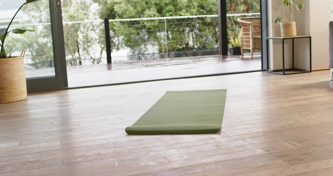 Camera starting recording and remaining fixed on green exercise mat in studio for workout tutorial