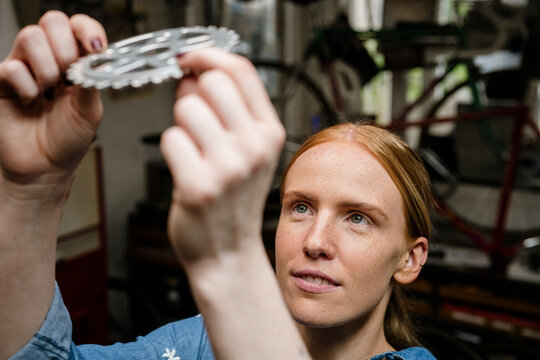 Urban bike enthusiast checking gear in workshop with a smile