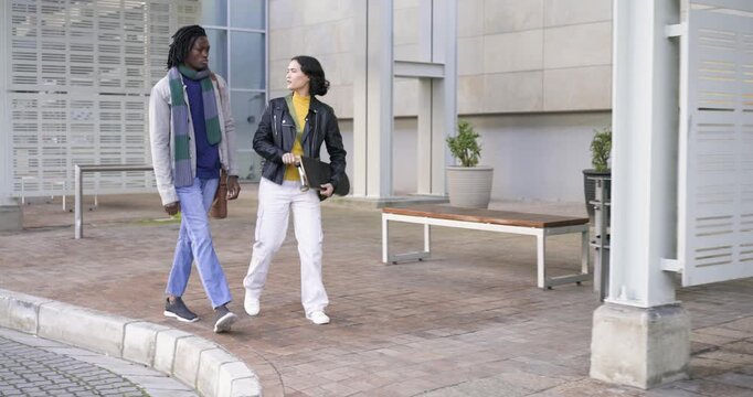 Pointing to skateboard diverse friends at plaza discussing skate route with man checking smartphone