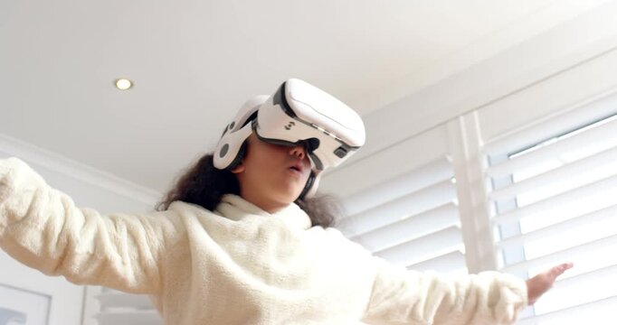 Girl lifting white VR headset to eyes in living room, reaching and swiping, exploring virtual world