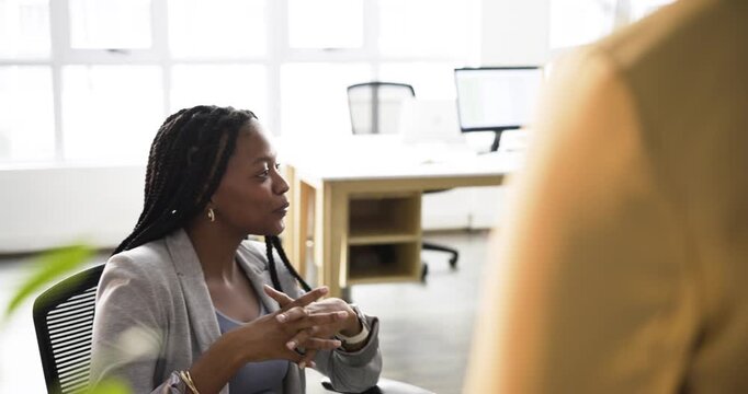 Diverse team in office discussing African American speaker entering gesturing South Asian nodding