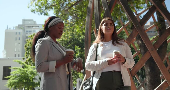 Diverse women talking under wooden trellis plaza right raising cup reading cell left checking watch