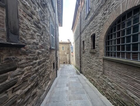 Vicolo in pietra tra edifici storici, con prospettiva profonda e atmosfera autentica di un borgo europeo antico
