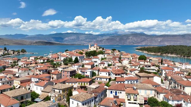 Aerial drone cinematic video from picturesque and traditional historic village of Galaxidi featuring landmark church of Agios Nikolaos, Fokida, Greece