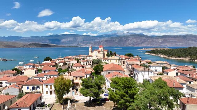Aerial drone cinematic video from picturesque and traditional historic village of Galaxidi featuring landmark church of Agios Nikolaos, Fokida, Greece