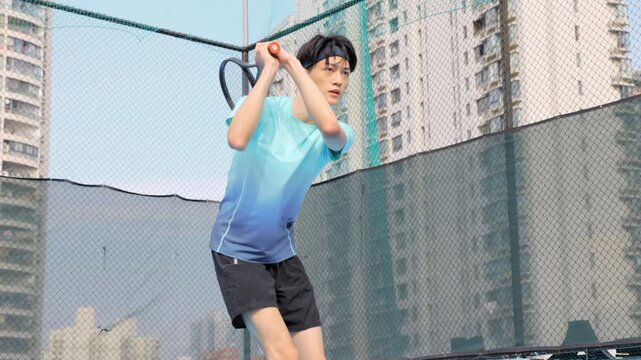 Portrait of enthusiastic intense male tennis player in a sportive form actively, wearing a visor and man holding a racket preparing for serve on outdoor court in mid-match concentration, focused gaze