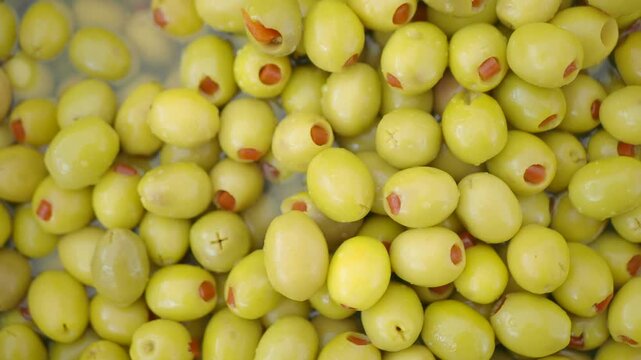 Fresh green olives stuffed with red pimento served in a metal tray close up
