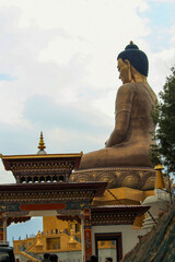 Obraz premium The image features a golden statue at the Buddha Dordenma monument, a significant landmark located in Thimphu, Bhutan. 