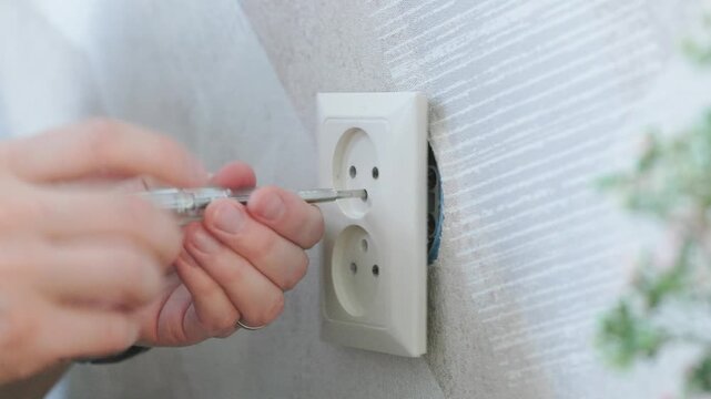 Electrician Removing Wall Socket For Repair