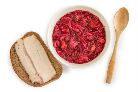 Food background with Beetroot soup Borscht in ceramic bowl and fat tail fat sandwich over white paper surface.