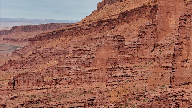 Aerial view of red rock formations carved by time, revealing layers of earth and sky in a dance of light and shadow, Moab, Utah, United States.