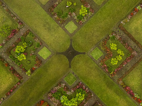 Aerial view of a symmetrical garden design with vibrant flowers and lush green grass creates a captivating mosaic of colors and textures, Cinchona, Costa Rica.