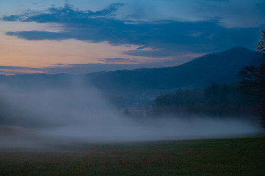 Thick fog spilling into a Cades Cove meadow at dusk in the Great Smoky Mountains, Tennessee