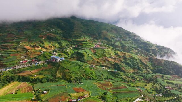 Drone flies forward, terraced mountain farms, dramatic storm clouds, Philippines