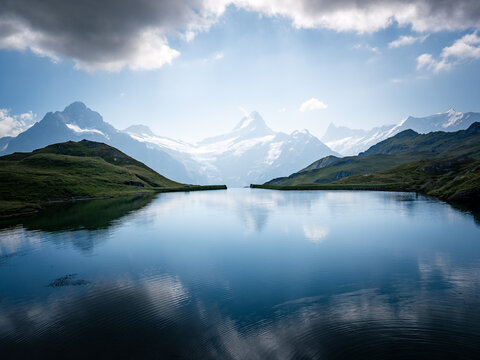 Aerial view of a serene alpine lake mirroring the snow-capped peaks of the Eiger and surrounding mountains, Grindelwald, Switzerland.