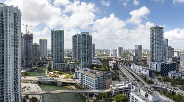Aerial view of the vibrant Brickell Key waterfront district, where emerald waters meet the towering skyscrapers under a vast sky, Brickell, Florida, United States.