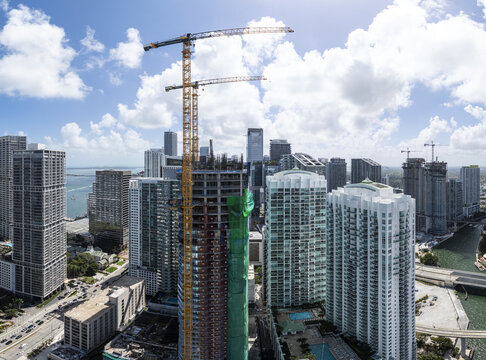 Aerial view of gleaming skyscrapers piercing the bright skyline, a symphony of glass and steel reflecting the azure waters below, Brickell, Miami, Florida, United States.