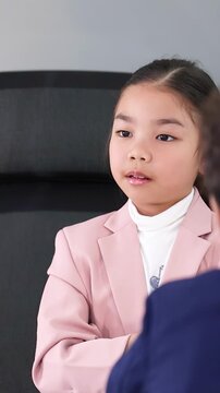 Young Asian Girl in Pink Blazer Leading a Business Meeting