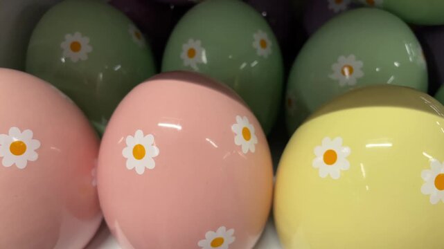 Colorful porcelain Easter eggs with floral patterns displayed for sale in a store, celebrating seasonal decor and holiday traditions.