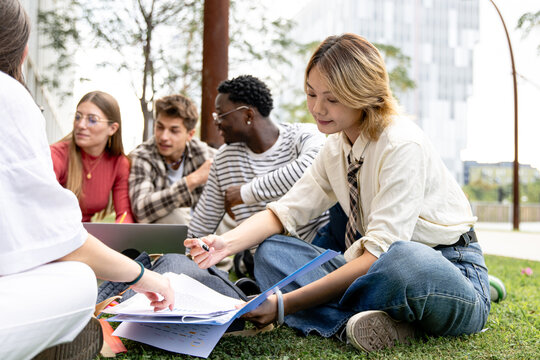 A group of diverse students working together outdoors on a collaborative project activity
