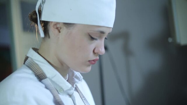 A female chef cooks in the kitchen at home wearing a chef's costume