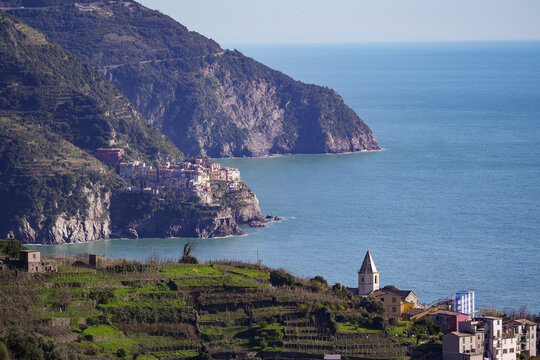View of the vibrant village clinging to the rugged cliffs, turquoise water meeting the shore, creating a breathtaking coastal panorama, Manarola, Liguria, Italy.
