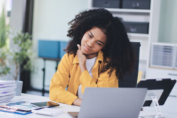 Businesswoman experiencing discomfort and pain in her lower back while sitting at her desk, working...