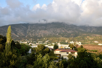 Obraz premium Scenic mountain landscape with houses in valley under cloudy sky rural mediterranean village in Turkey morning light hills and green trees outdoor nature travel real estate concept