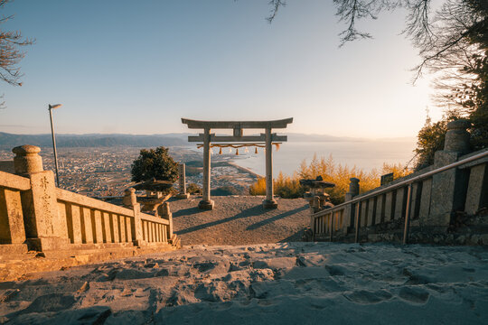 View of the iconic Takaya Shrine, its torii gate framing a distant panorama of land and sea under a serene sky, Kanonji, Kagawa, Japan.