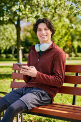 Fototapeta premium Young man in stylish outerwear enjoys a spring day while relaxing outdoors