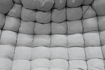 Fototapeta premium Textured grey upholstery with rounded padded squares showing gradient effect