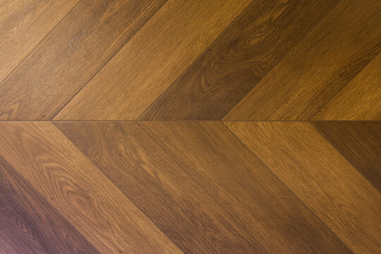 Textured wood floor surface with brown chevron pattern design