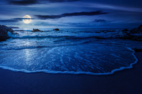 mysterious sandy sea beach at night. full moon over scene on cold summer vacation season. beautiful view of waves washing the sand. generic image of seascape and sky for advertising background