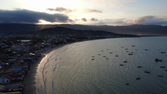 Drone slide right over the bay of a small fishing town 