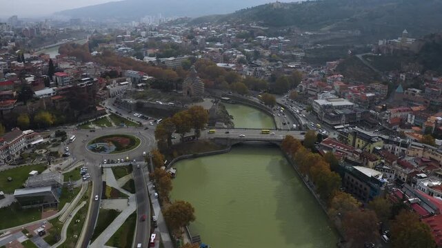 Aerial view of Old Tbilisi, Georgia with colorful rooftops, historic churches, Narikala Fortress on the hill, and dense urban architecture. Scenic panorama captures authentic Caucasus atmosphere.