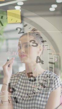 Teen reaching to write on glass board in office, clock overlay syncing with marks, planning pitch