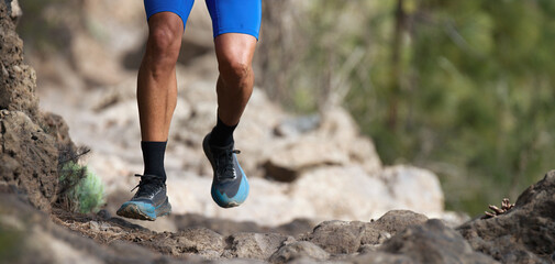 Walking or running exercise legs on rocky footpath in bright forest achievement fitness adventure and exercising in spring or summer nature motivation and inspirational activity