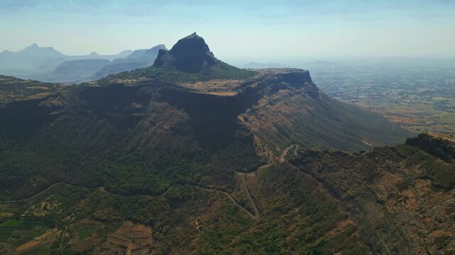 Drone aerial shot of Shree Saptashrungi Nivasini Devi Shaktipeeth, Vani Nashik capturing the sacred hilltop temple amid lush mountains, clear blue skies and bright sunlight showcasing spiritual beauty