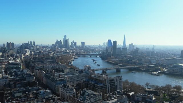 Scenic flight over River Thames towards City of London financial district with famous skyscrapers, highlighting Waterloo Bridge and Blackfriars Bridge