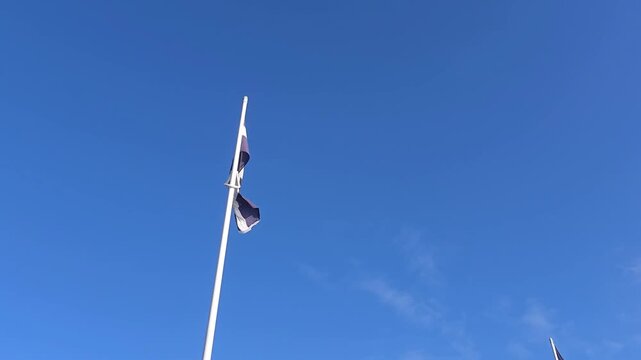 Cornish Flag on Pole Against Blue Sky in Cornwall England Looking Up