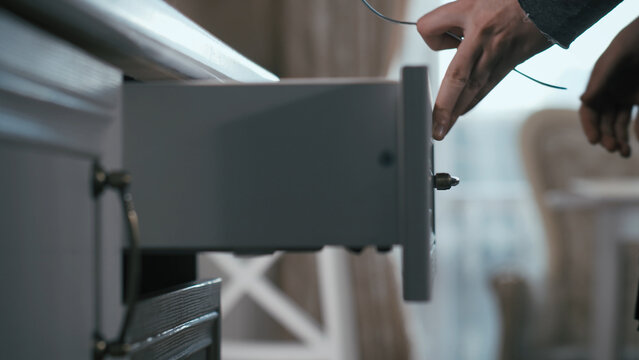 Person Unlocking Wooden Drawer With Key in Modern Interior, have fun and enjoy