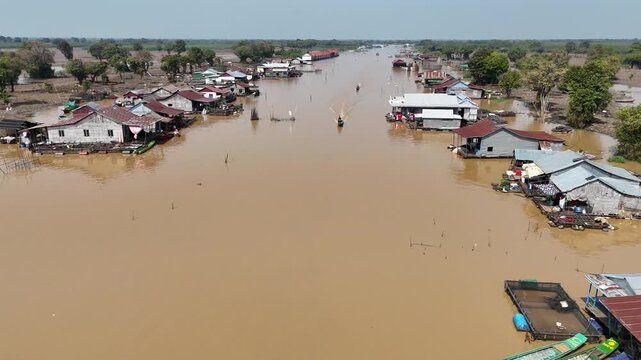 Aerial view of houses on stilts surrounded by water, creating a serene yet surreal landscape of Chong Kneas, Cambodia.