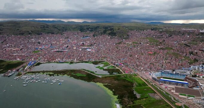 Densely constructed and populous Puno city aerial view from over Lake Titicaca
