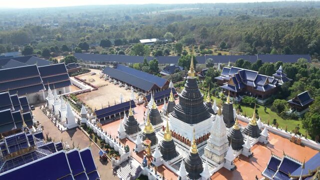 Aerial view of the golden spired temples of Wat Phra Kaew contrast against the blue roofs and lush greenery, Wat Phra Kaew, Thailand.