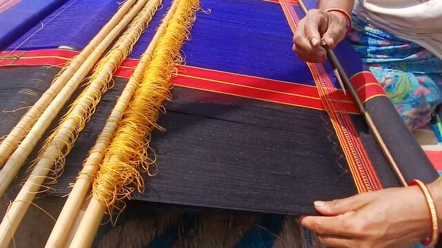 Handloom weaver working in loom	
