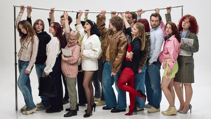 Passengers standing tightly packed holding rail in crowded public transport scene. Concept of...