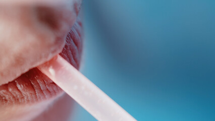 Fototapeta premium Close-Up of Woman Applying Lip Balm with Blue Background, have fun and enjoy
