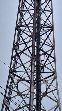 Telecommunications tower technology rising into an overcast sky showcasing modern communication infrastructure and power lines