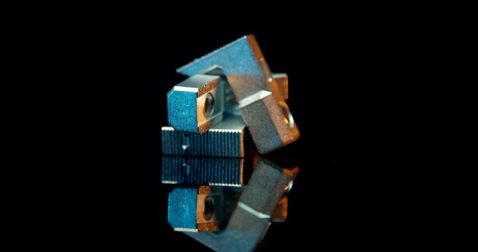 Macro shot of small metal hammer nut fasteners for aluminum profiles on reflective black surface