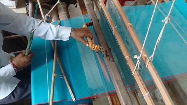 Handloom weaver working in loom